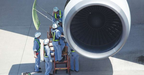 Aircraft maintenance workers servicing airplane engine